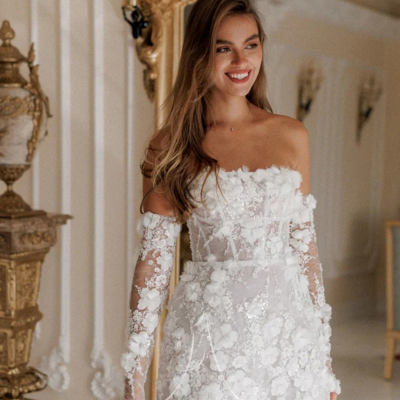 Elegant women's floral wedding dress with delicate sheer sleeves, perfect white bridal gown for special occasions.