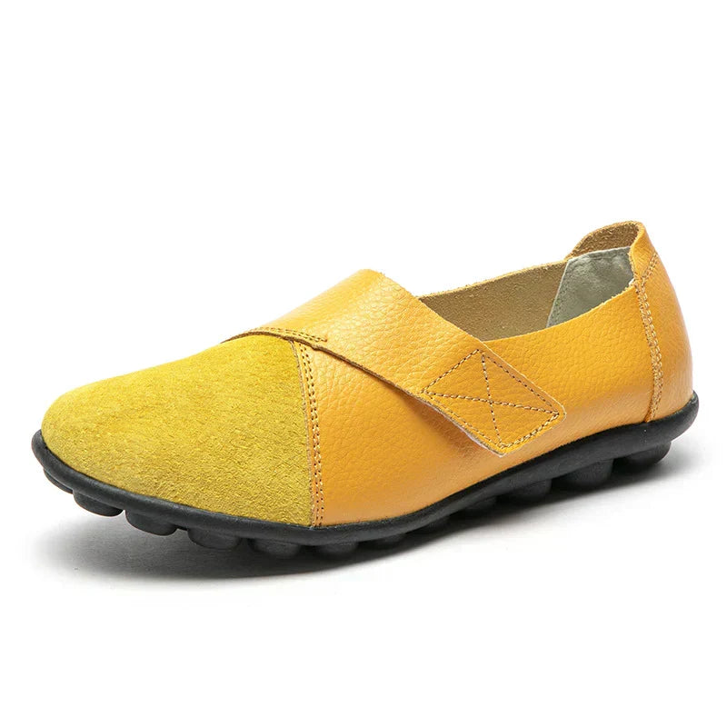 Smart casual unisex slip-on footwear, flat, round toe, featuring distinct stitched paneled details.