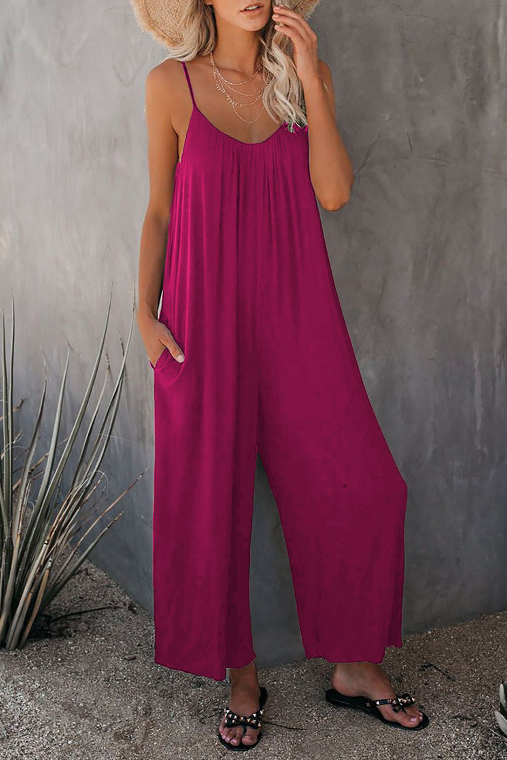 Feminine chic women's beach jumpsuit, sleeveless with plunging neck & pockets for summer vacation style.
