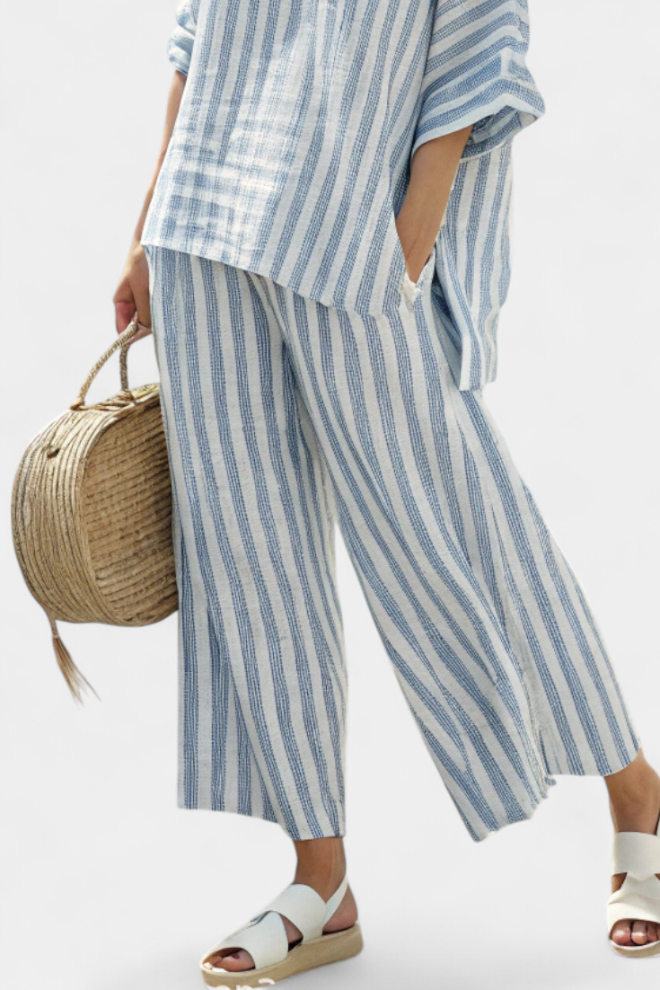 Stylish women's matching blue striped top and relaxed trousers set, great for a casual chic summer look.