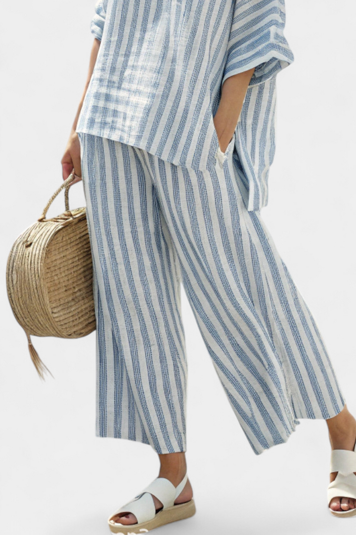 Stylish women's matching blue striped top and relaxed trousers set, great for a casual chic summer look.
