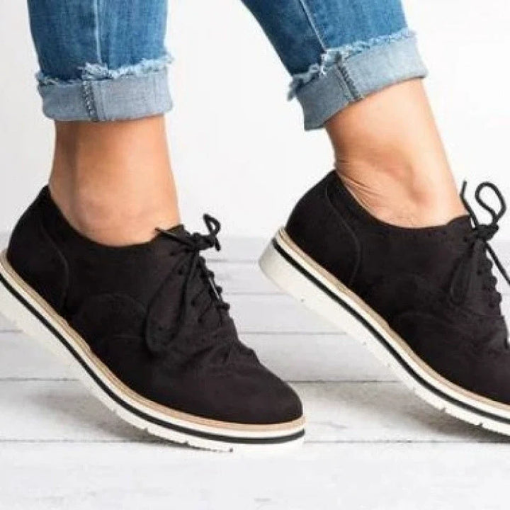 Front view of classic women's brogue shoes, highlighting the elegant perforated design & traditional lacing.
