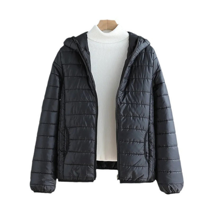 Front view of a women's black quilted transitional jacket with hood, full zip & pockets.