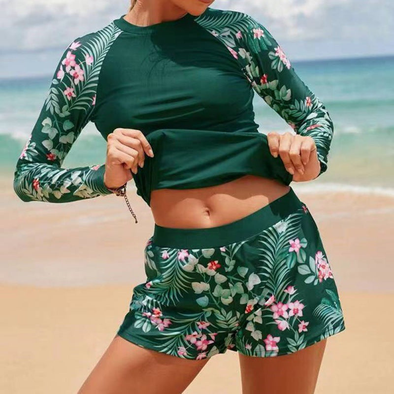 Stylish women's long sleeve rash guard, one-piece swimsuit, with elegant leaf print for beachwear.