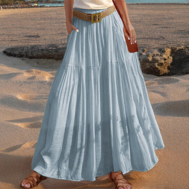 Flowy women's long pleated skirt, versatile for casual or elegant occasions, with pockets.
