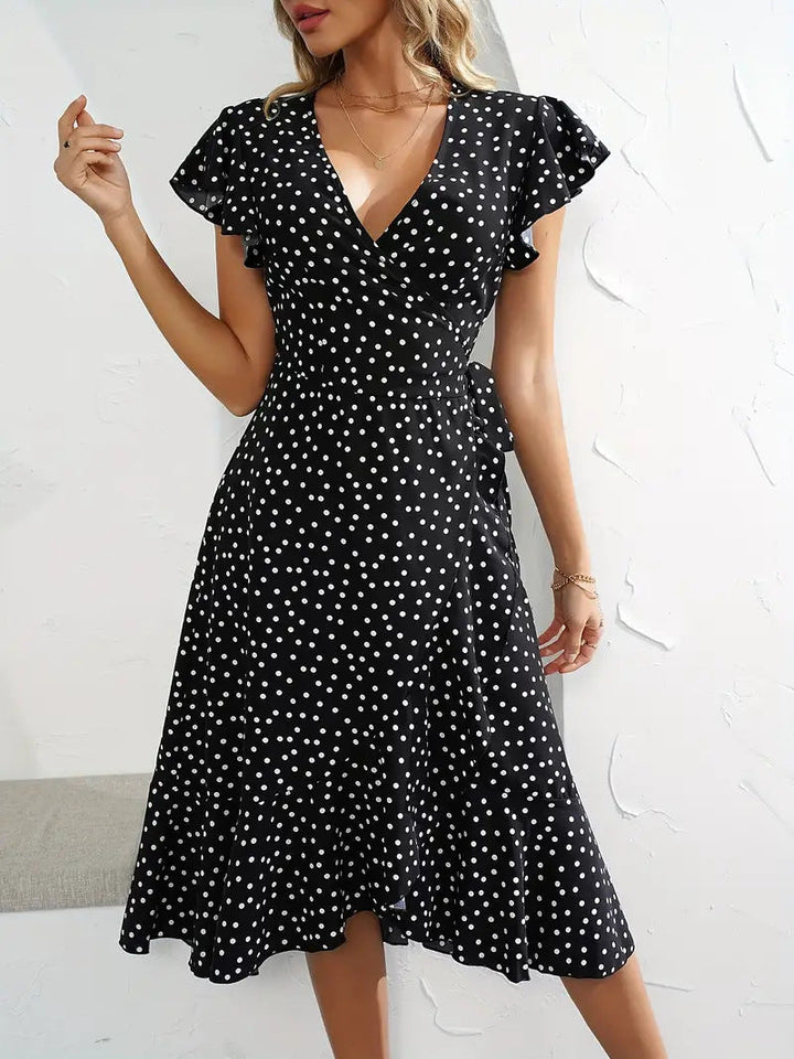 Stylish women's short polka dot wrap dress with a playful skirt, perfect for day or party.