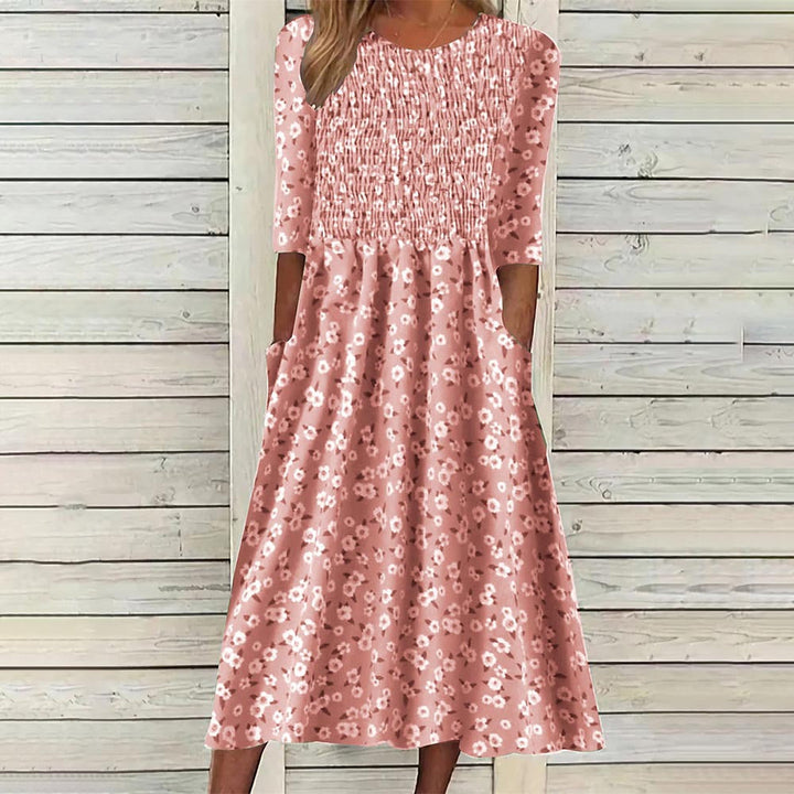 Close-up of a women's floral smocked midi dress, showcasing intricate smocking details & vibrant print.