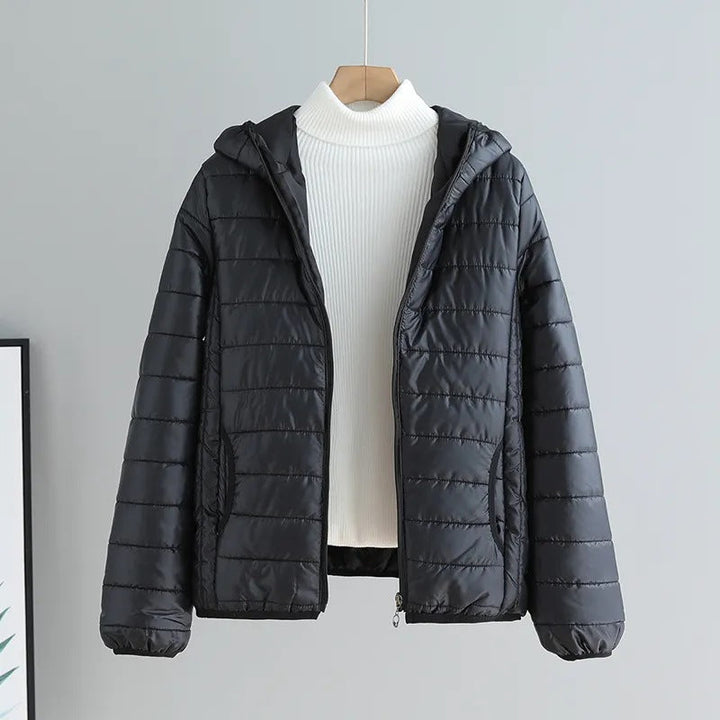 Woman wearing a versatile women's quilted hooded jacket, walking outdoors in spring.