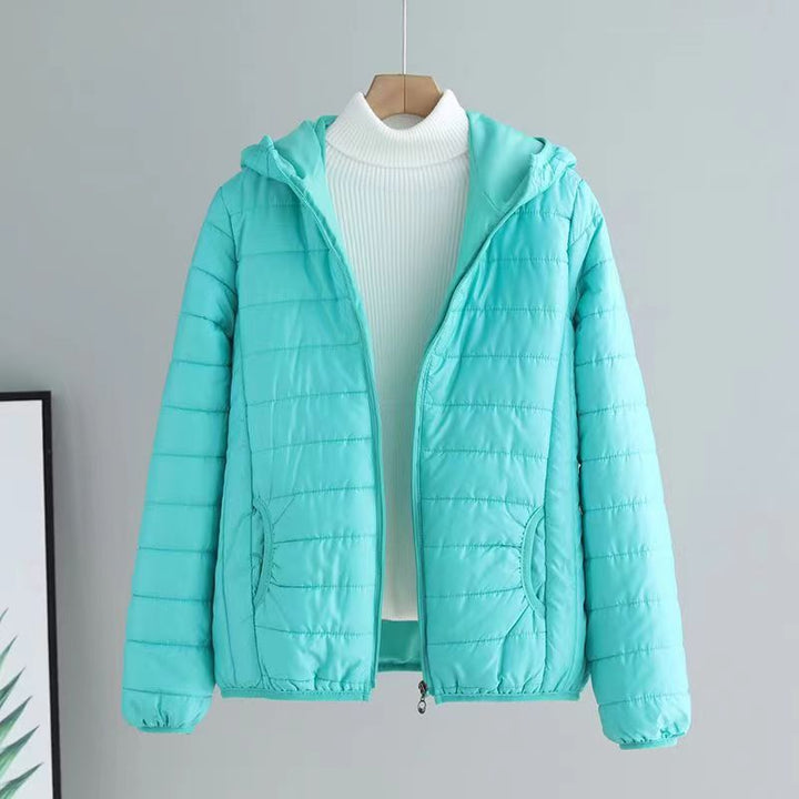 Detail of the zipper & pockets on a women's quilted transitional jacket.