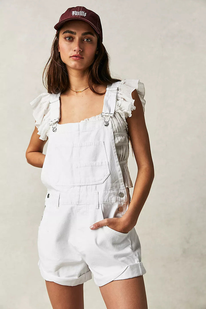 Close-up of women's overall shorts showing adjustable shoulder straps, button details, and practical front pockets.