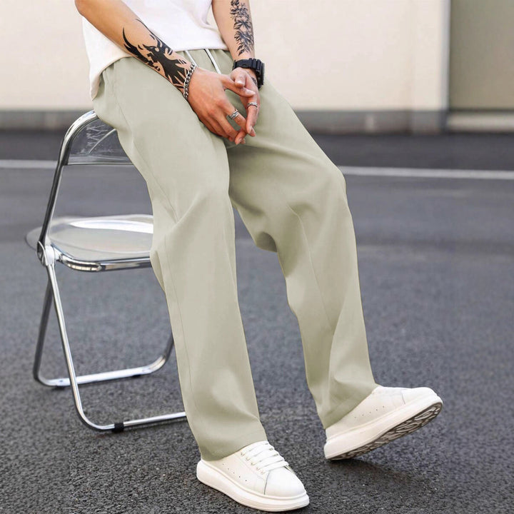 Black men's leisure pants, loose fit & elastic waist. Versatile casual wear for modern men.