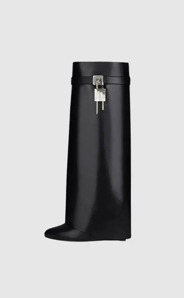 Modern knee-high wedge boots for women, featuring a glossy material & distinctive sculptural design.