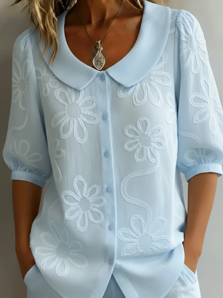 Detailed embroidered floral women's shirt, short sleeve, round neck, offering versatile everyday elegance.