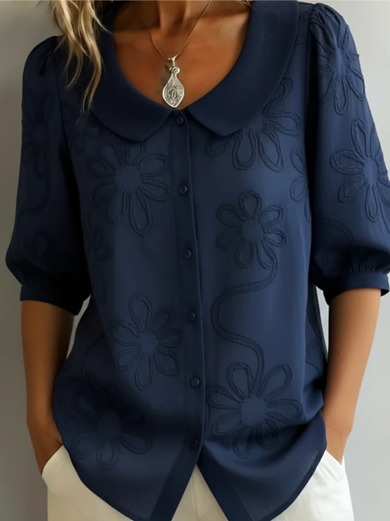 Elegant women's floral embroidered blouse featuring a round neck and short sleeves. A versatile button-down top.