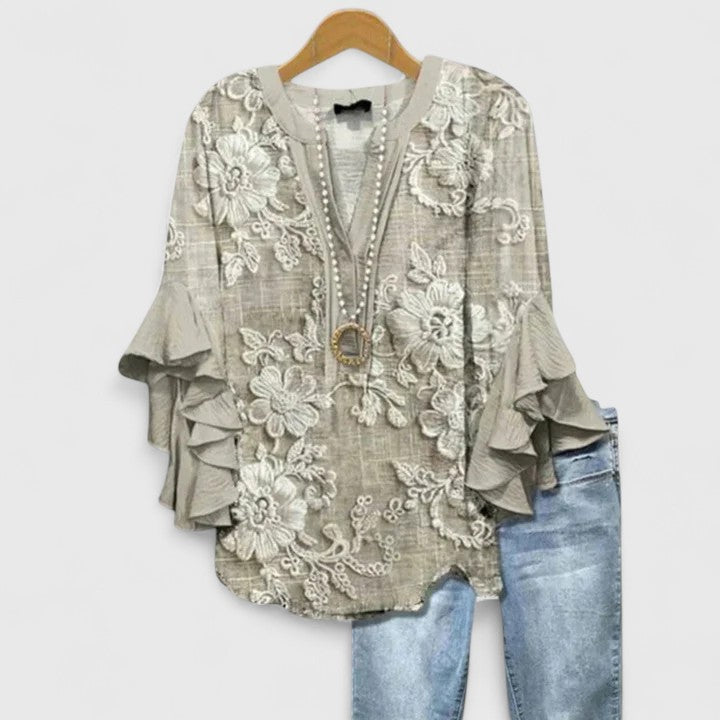 Chic women's floral blouse featuring vibrant floral print and graceful ruffle sleeves, a fashionable top.