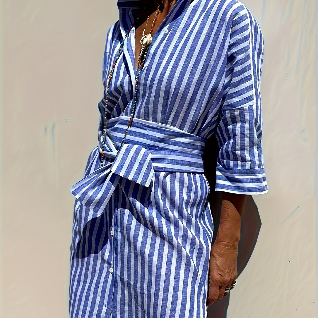 Side view of a women's belted striped dress, showcasing its flattering cut and movement.