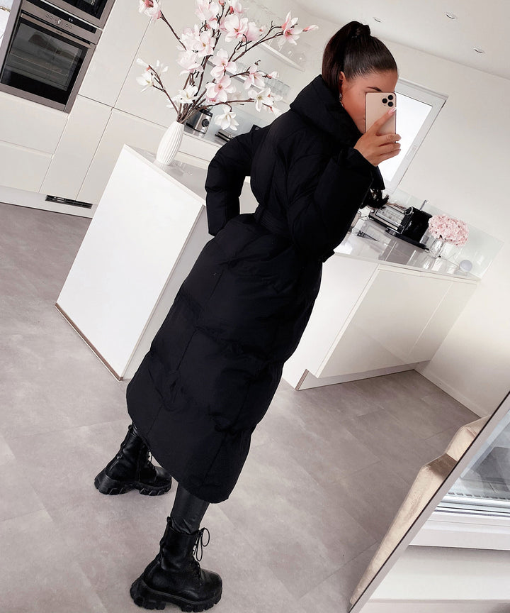 Women's warm outerwear: a long quilted winter coat with a sophisticated, elegant silhouette.