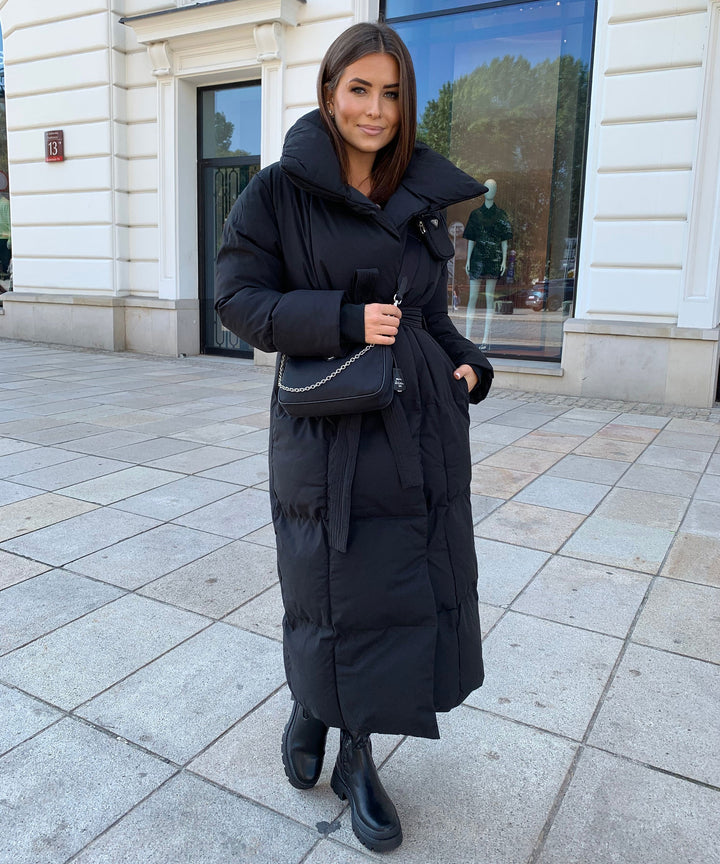 Chic women's long quilted winter coat, perfect outerwear for a sophisticated, elegant look.