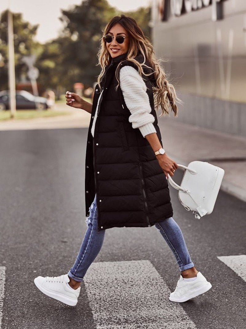 Warm women's long hooded puffer vest, featuring a chic quilted design. Essential winter and fall outerwear for women.