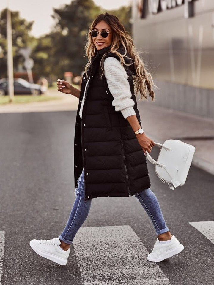 Warm women's long hooded puffer vest, featuring a chic quilted design. Essential winter and fall outerwear for women.