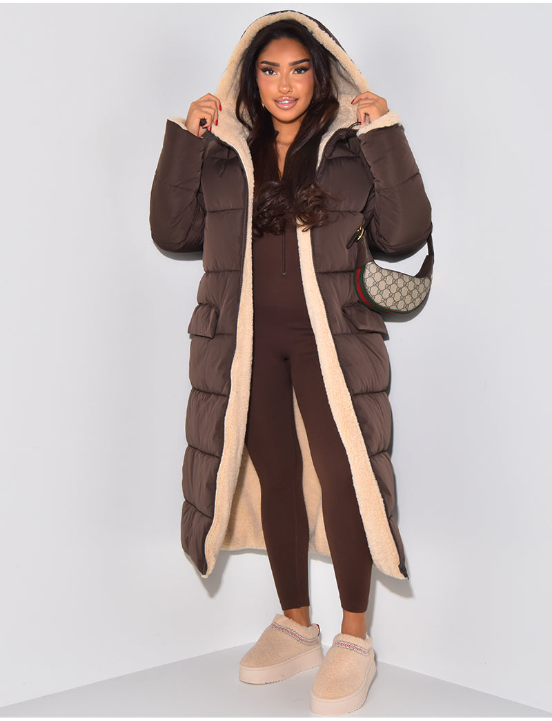 Cozy women's hooded longline winter jacket, reversible for two looks. Warm fashion for cold weather versatility.