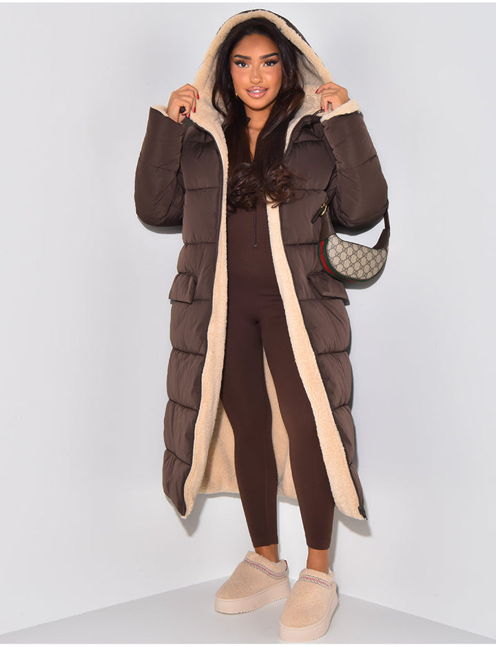 Cozy women's hooded longline winter jacket, reversible for two looks. Warm fashion for cold weather versatility.