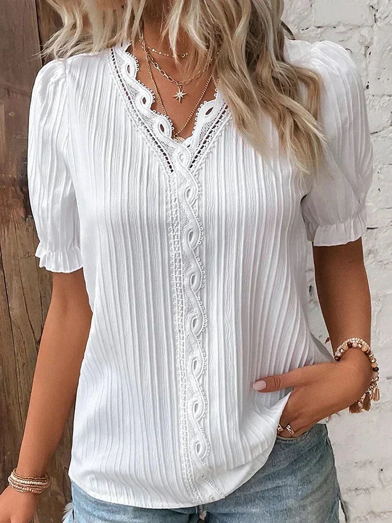 White women's pleated V-neck blouse with short sleeves & button details. Ideal stylish top for spring fashion.