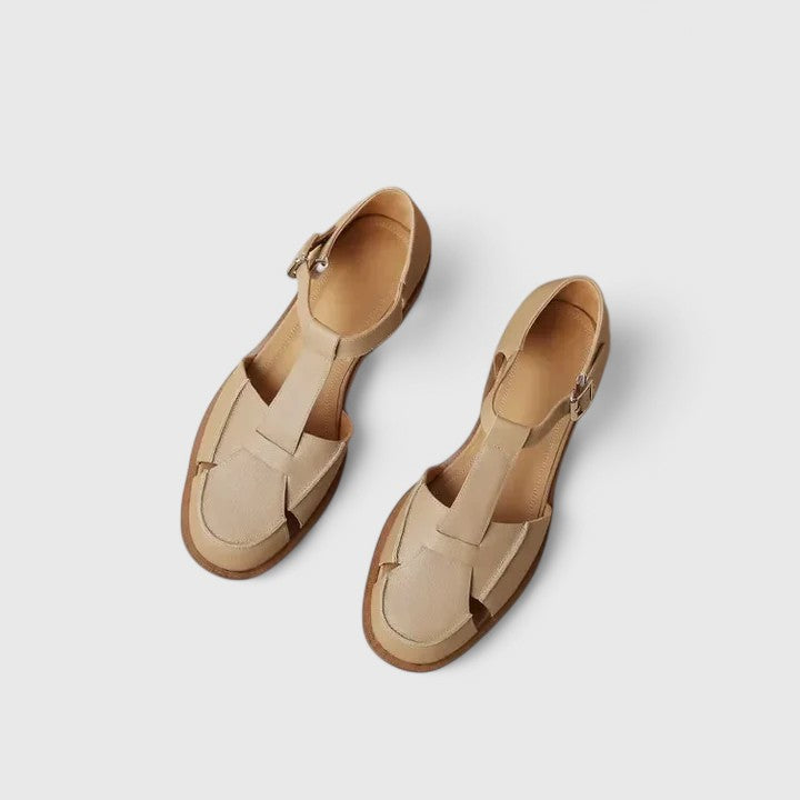 Brown closed-toe T-strap sandals for women, featuring a stable block heel and secure adjustable strap.