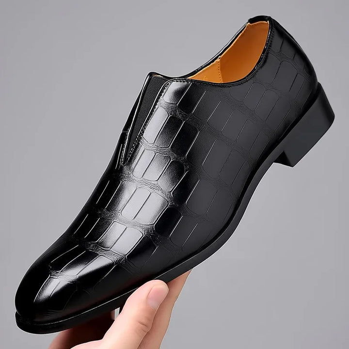 Modern men's glossy black crocodile pattern slip-on brogues, ideal elegant footwear for business and special occasions.