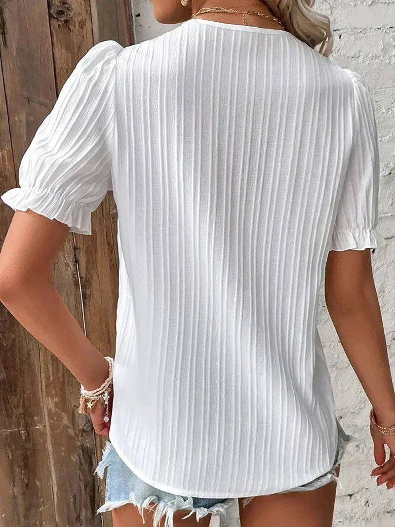 Casual women's V-neck blouse featuring pleats & elegant button accents. Perfect for office wear or summer.