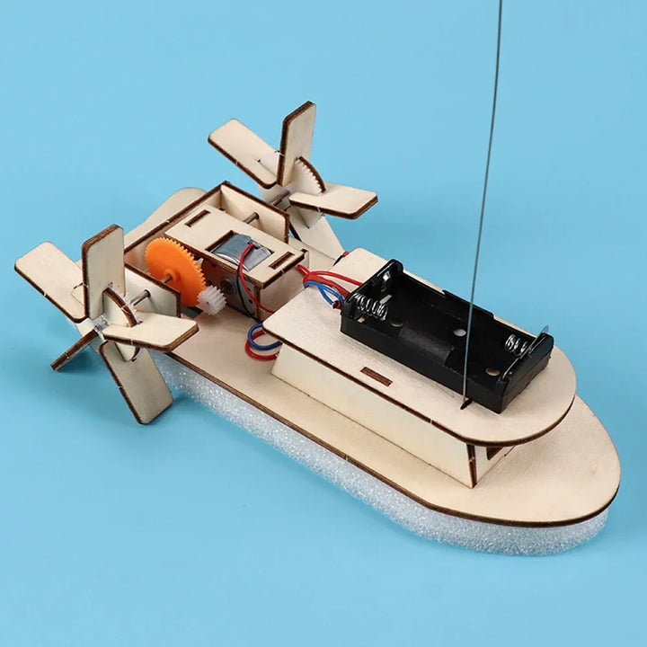 Kids' science project: understanding electricity & mechanics with a wooden toy boat kit.