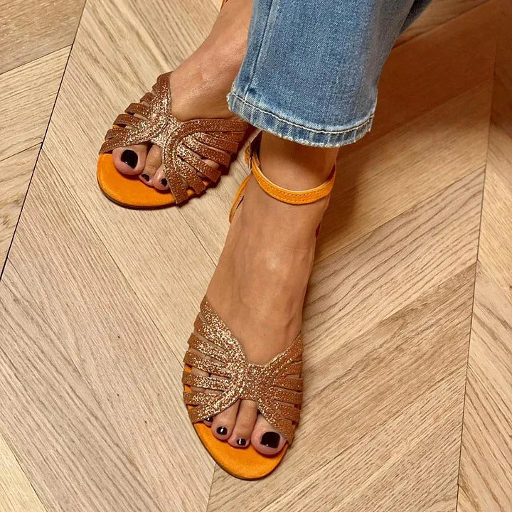 Stylish women's flat ankle strap sandals in orange, offering comfortable and casual elegant summer footwear.