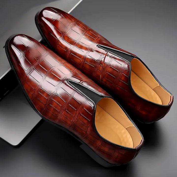 Close-up of men's glossy crocodile texture on elegant slip-on brogues, high-quality formal fashion footwear.