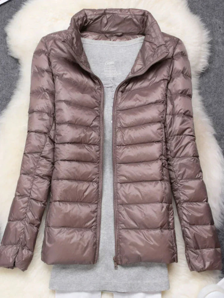 Weather-resistant women's ultra-light hooded jacket. Insulated for warmth in winter & travel.