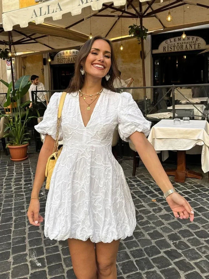 Elegant white floral mini dress featuring puff sleeves; ideal casual day dress for women's summer fashion.
