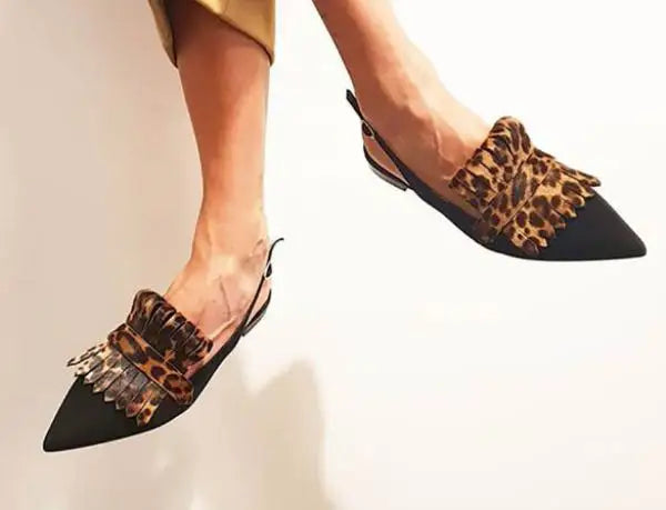 Detail of the elegant heel and open-back strap on women's pointed-toe dress pumps.