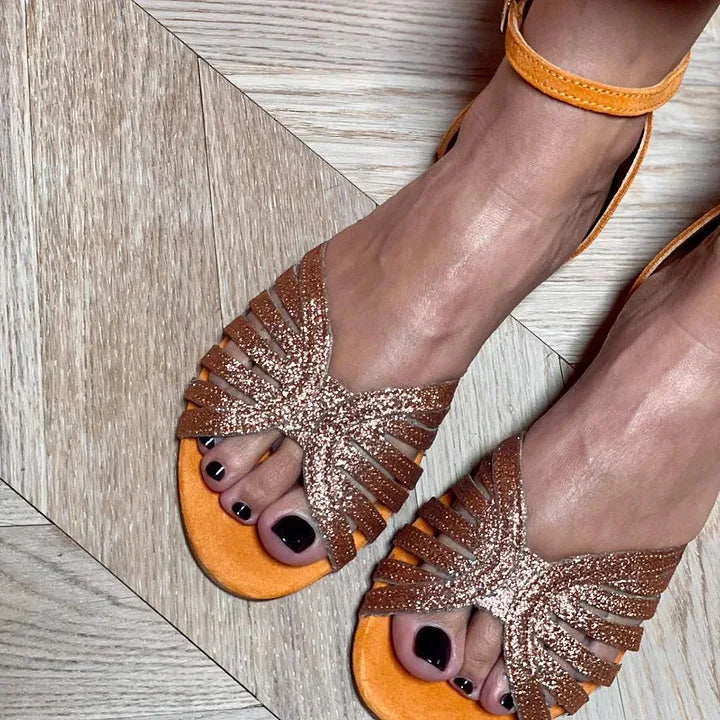 Elegant orange flat sandals for women, featuring a secure ankle strap for comfortable and fashionable casual wear.