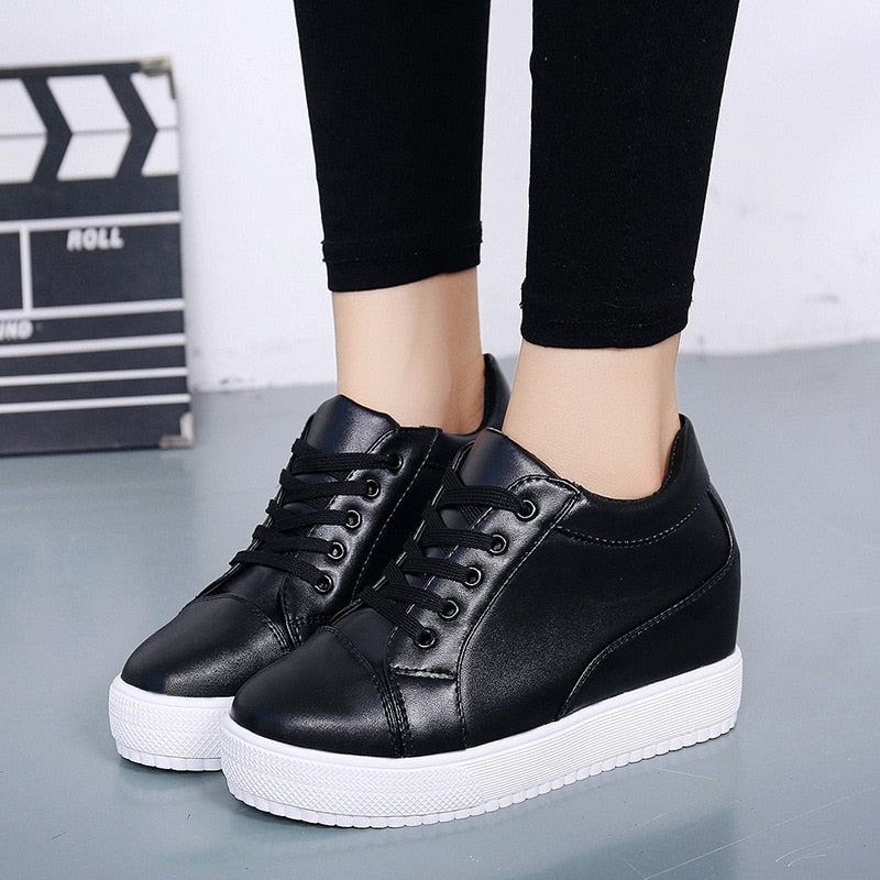 Black women's lace-up wedge sneakers. Modern platform design for comfortable, stylish casual wear & elevated everyday fashion.