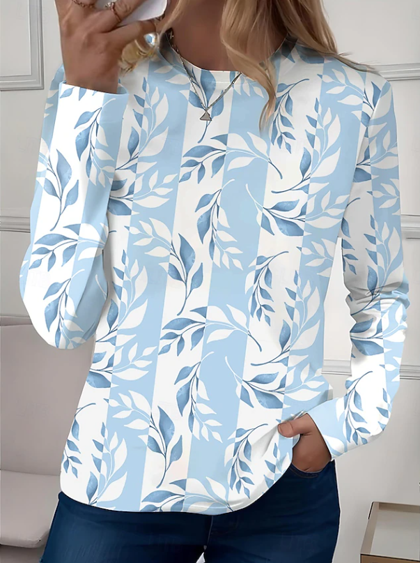 Detail of a feminine floral patterned long sleeve crew neck shirt blouse. Showcases soft fabric and vibrant print.