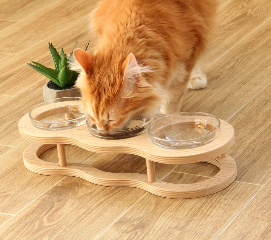 Elevated wooden feeder with two glass bowls & non-slip holder for dogs & cats. Comfortable pet feeding.