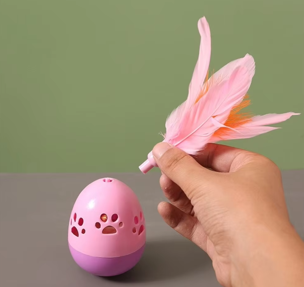 Cat pouncing on an interactive feather ball toy, providing endless feline entertainment & exercise.