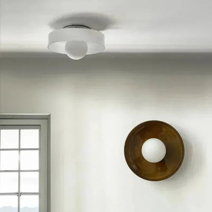Modern Scandinavian glass ceiling lamp providing soft ambient light in a living room.