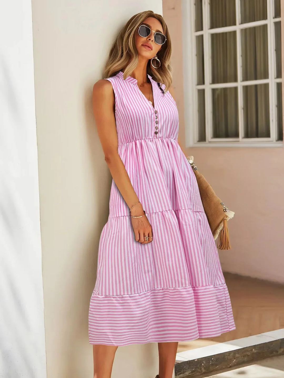 Trendy women's striped sleeveless midi dress. Chic, casual tiered button-down style for spring/summer fashion.