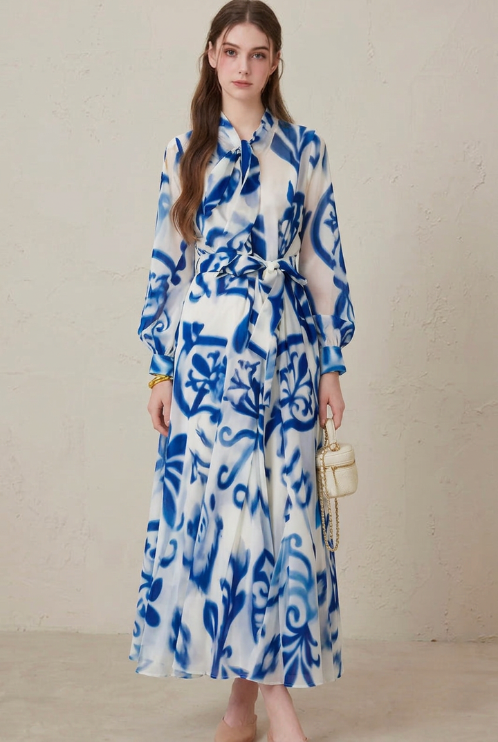 Women's elegant blue porcelain print long sleeve maxi dress with tie-neck and belted waist for occasion wear.