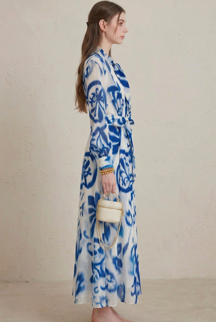 Close-up of women's blue porcelain floral print long sleeve maxi dress, highlighting fabric and tie-neck details.