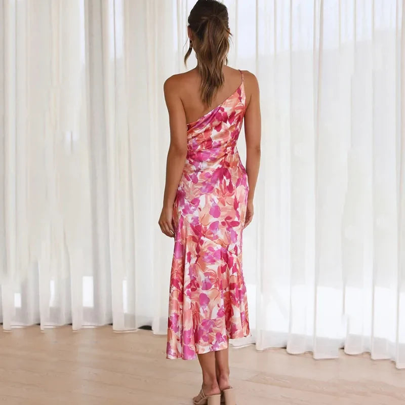 Elegant women's one-shoulder floral midi dress with an asymmetrical hem. Stylish pink summer occasion dress.