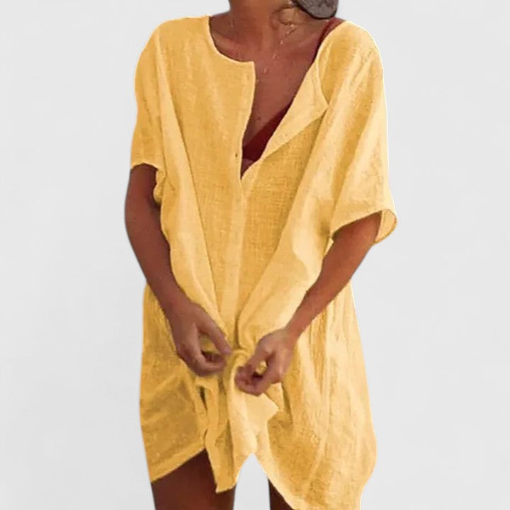Side profile of a women's elegant tunic dress, highlighting its relaxed fit and stylish cut for summer fashion.