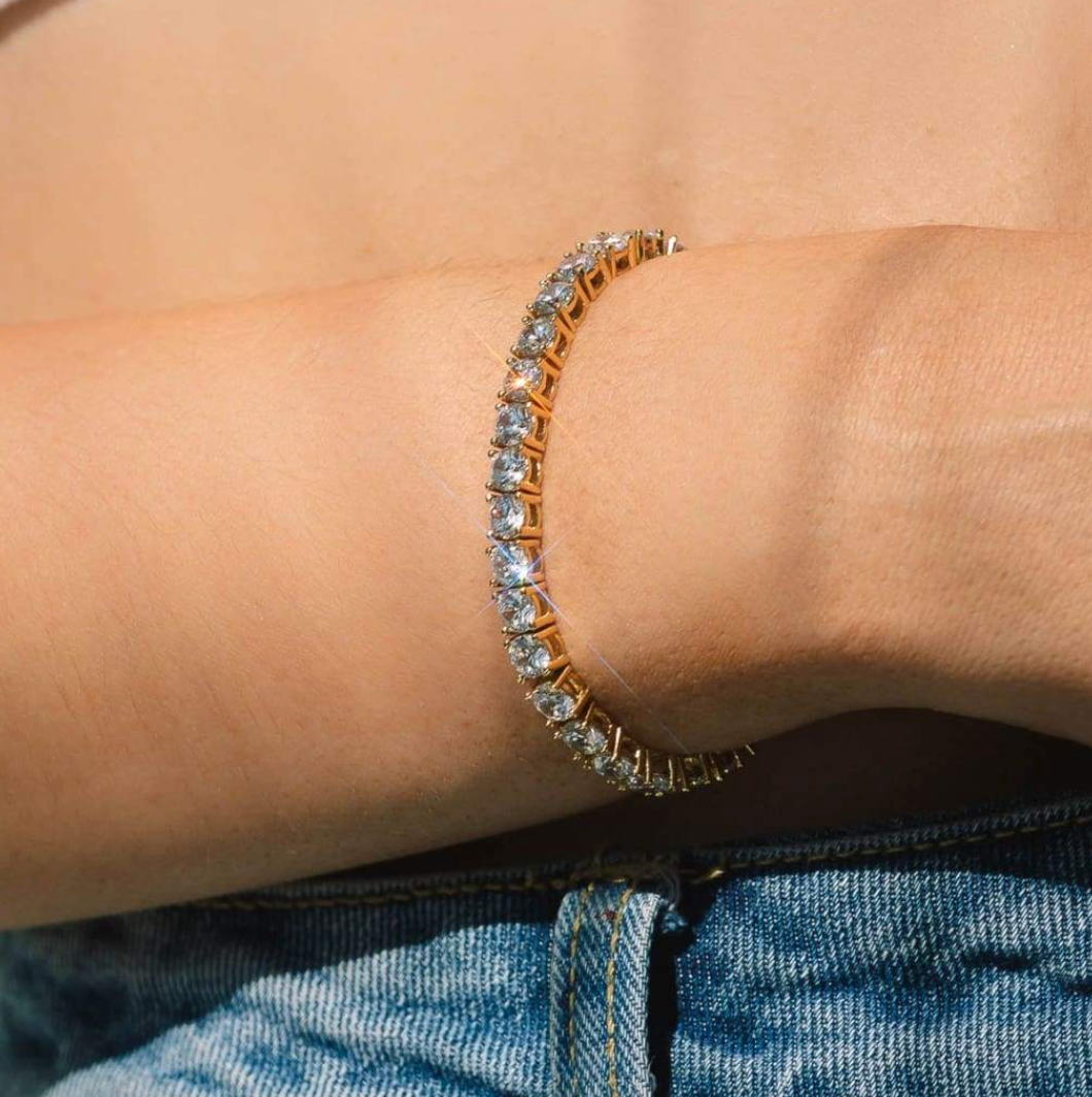 Elegant gold-plated women's crystal tennis bracelet with sparkling adjustable design, a classic fashion accessory.