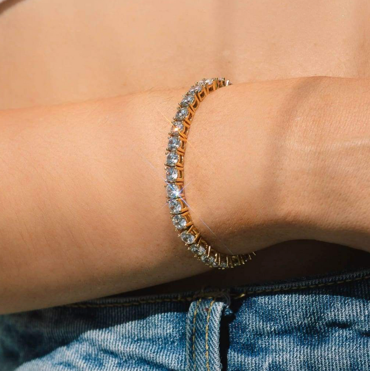 Elegant gold-plated women's crystal tennis bracelet with sparkling adjustable design, a classic fashion accessory.