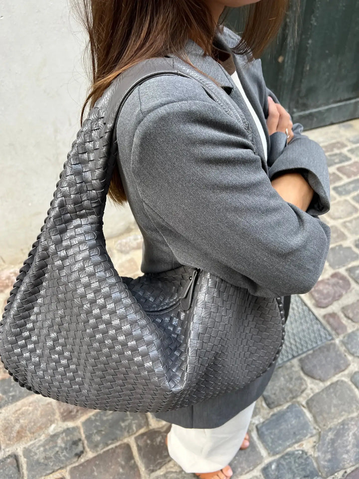 Side profile of a chic vegan leather shoulder bag, perfect for the modern elegant woman.